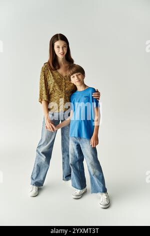 A young mother and her son stand together in casual outfits, embracing family love and connection. Stock Photo