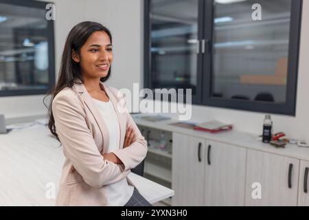 Portrait of a young successful Indian woman, an industrial company CEO in her office. Employment, career, and business concepts. Stock Photo