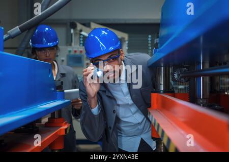Engineers check control heavy machinery in Industrial factory for maintenance and safety. Stock Photo