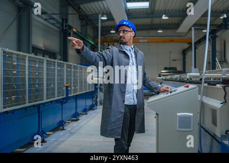 African American professional, a factory engineer updating industrial control panel. Modern industry, people, and automating concepts. Stock Photo