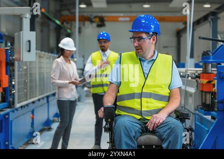 Two workers talking with a female manager showing manufacturing operations and plans on a digital tablet. Modern industry concept. Stock Photo