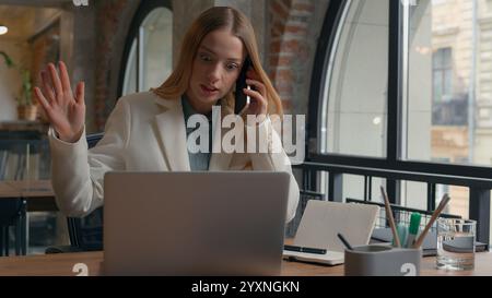 Stressed multitasking busy Caucasian office worker manager employer female businesswoman girl business woman work many tasks talking mobile phone Stock Photo