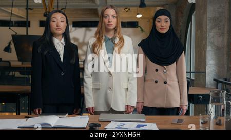 Multiracial business women three multiethnic diversity Caucasian Asian Korean Muslim Islamic hijab businesswomen girls colleagues coworkers team Stock Photo