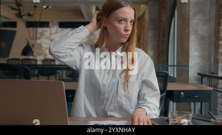 Business financial data work in office confused Caucasian girl analyze diagrams documents businesswoman female business woman scratching head Stock Photo