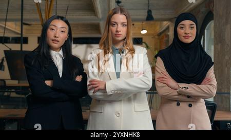 Multiracial business women three multiethnic diversity Caucasian Asian Korean Muslim Islamic hijab businesswomen girls colleagues coworkers team Stock Photo