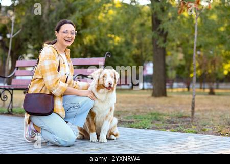 Young woman with Australian Shepherd dog in park Stock Photo