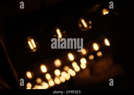 A close up of a dark room with three light switches. The switches are lit up, creating a warm and inviting atmosphere Stock Photo