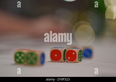 A group of wooden dice with different colors and numbers on them. Concept of fun and playfulness, as the dice are scattered on a table, ready to be ro Stock Photo