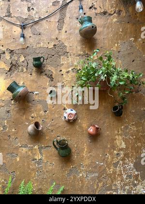 A plant and clay pots adorn a stone wall. Stock Photo