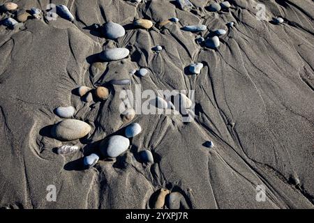WA28034-00...WASHINGTON - Water canals around rounded pebbles in the sand at Ruby Beach in Olympic National Park. Stock Photo