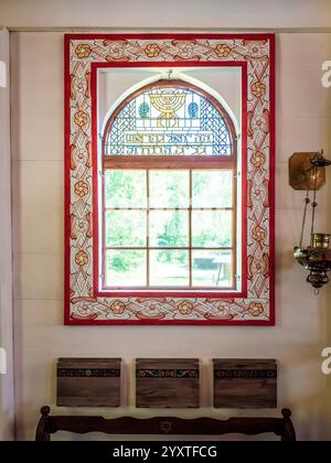 Sanok, Poland - May 4, 2024. Brightly lit colorful stained glass windows in a replica of an 18th century wooden synagogue from Połaniec. Stock Photo