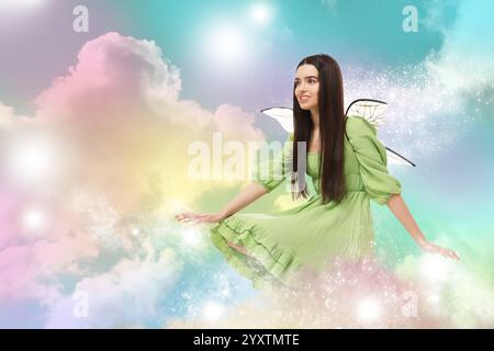 Ethereal fairy casting magic lights among fluffy clouds in colorful sky. Beautiful girl with wings Stock Photo