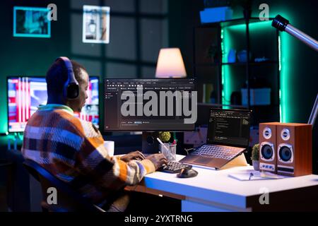 African american computer scientist in home office programming code on pc. Freelancing developer solving tasks for an IT job, writing lines of code at his personal office, cybersecurity. Stock Photo