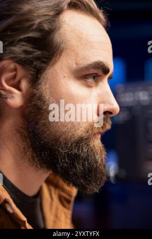 Focus on developer typing code on computer in blurry background to futureproof company network from downtimes and unexpected system failures, increasing data security, close up shot on face Stock Photo
