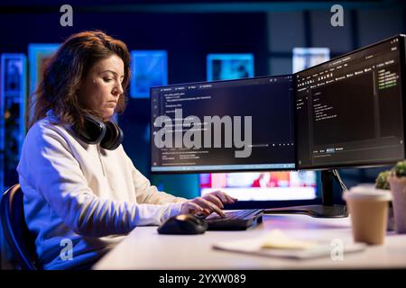Freelancing professional working from home developing software in Java programming language using PC. Software technician in apartment writing lines of code on computer using keyboard Stock Photo