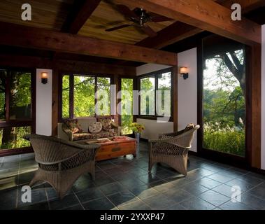 Interior of four season porch with tile floor and floor to ceiling windows Stock Photo