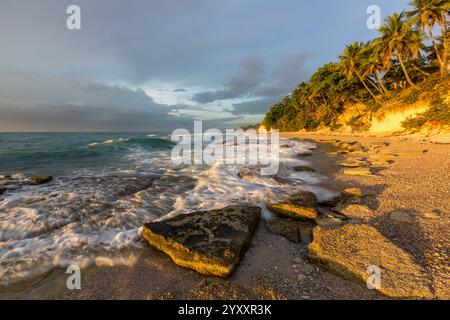 Waves breaking on the rocks on a beach at sunrise. Photographed near Barahona, Dominican Republic. Stock Photo