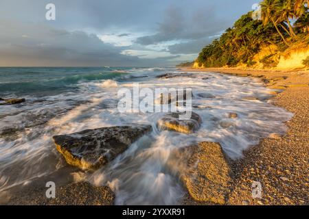 Waves breaking on the rocks on a beach at sunrise. Photographed near Barahona, Dominican Republic. Stock Photo