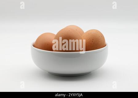 Fresh brown eggs in a white bowl isolated on white background Stock Photo
