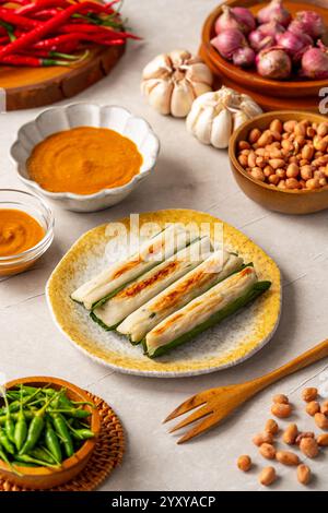 Otak-otak is a Southeast Asian fish cake made of ground fish meat mixed with spices and wrapped into leaf parcels. Stock Photo