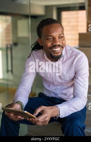 Successful African American businessman reading business graphs and stock charts on digital tablet Stock Photo