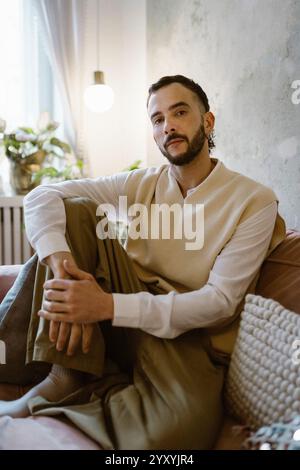 Portrait of man in casuals sitting on sofa at home Stock Photo