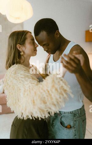 Romantic multiracial young couple dancing with each other at home Stock Photo