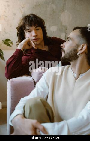 Man looking at boyfriend leaning on elbow at home Stock Photo