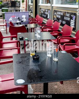 outdoor seating area of a bar or restaurant depicting empty beer glasses and ashtrays, as expected at this type of establishment Stock Photo