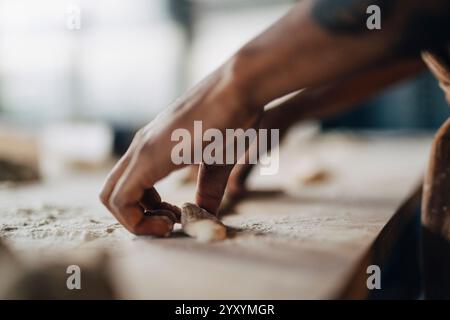 Hands of male baker kneading dough for pastry on table at bakery Stock Photo