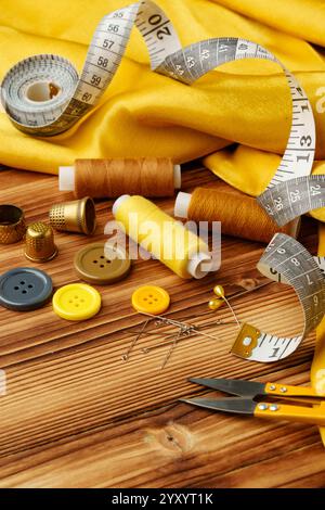 Crafting tools and materials arranged on a wooden table for sewing projects Stock Photo