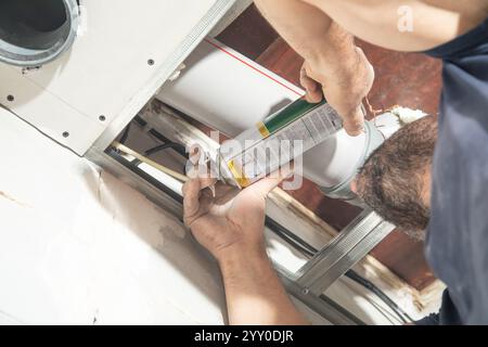 Worker using Polyurethane foam at home. Stock Photo