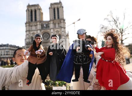 Paris, France. 15th Dec, 2024. Chinese actors perform a hand-puppet theater play 'Notre-Dame de Paris' in front of the Notre-Dame de Paris cathedral, in Paris, France, Dec. 15, 2024. Chinese actors staged a flash mob performance of hand-puppet theater play 'Notre-Dame de Paris' in front of the newly reopened Notre-Dame de Paris cathedral, as part of the Chinese Tour in France's Most Beautiful Villages, an event designed to boost Franco-Chinese cultural exchanges. Credit: Gao Jing/Xinhua/Alamy Live News Stock Photo