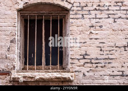Old barred window and decaying brick work Stock Photo