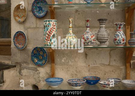 Göreme, Cappadocia, Türkiye : Traditional handcrafted plates, bowls, and decorative vases made of ceramics displayed in storefront of a souvenir gift Stock Photo