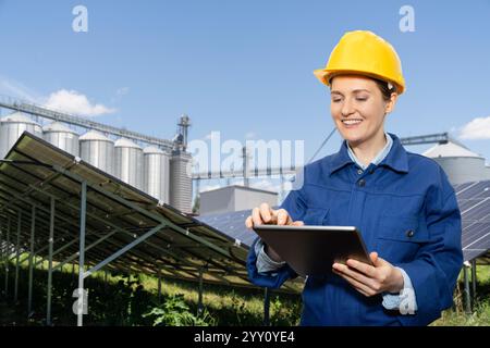 Engineer with digital tablet on a background of modern farm using renewable energy... Stock Photo