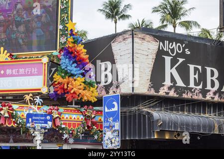 Christmas tree under palm trees on Bangla Walking Street Patong. Are Christmas decorations in Buddhist Thailand cultural appropriation? Patong, Kathu Stock Photo