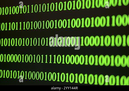 Green binary code in ordered rows on a dark background Stock Photo