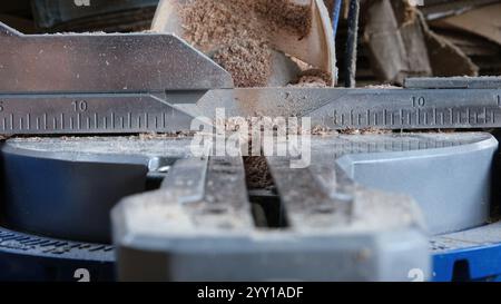 A detailed close-up view of woodworking precision tools, showcasing a ruler and saw blade surrounded by fine sawdust Stock Photo