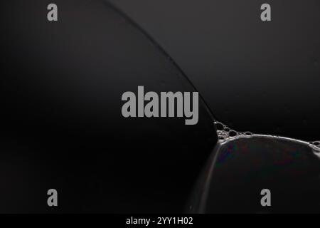 Transparent liquid, bubbles of thick liquid, silver reflection on dark background, gray colours, minimalistic water wallpaper Stock Photo