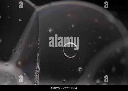 Transparent liquid, bubbles of thick liquid, silver reflection on dark background, gray colours, minimalistic water wallpaper Stock Photo