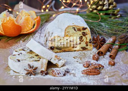 Sliced Authentic Stollen German Christmas Bread filled with raisins and marzipan, and powdered sugar on festive table Stock Photo