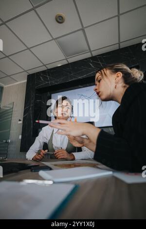 Focused team discussing project in modern office setting Stock Photo