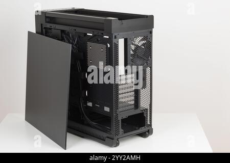 Side view of empty  big tower, PC case, chasis, without upper , left metal panel  and  tempered-glass right  panel. At the bottom is a cover for power Stock Photo