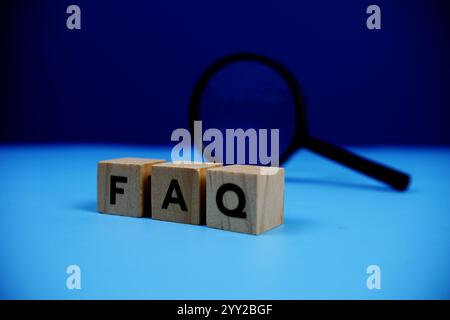 FAQ with wooden blocks alphabet letters and Magnifying glass on blue background Stock Photo