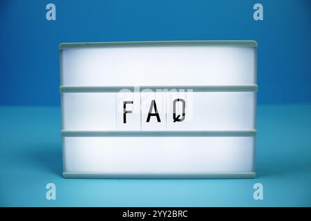 FAQ (frequently asked questions) letterboard text on LED Lightbox on blue background Stock Photo