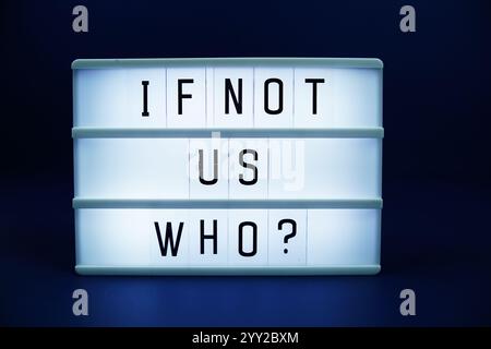 If not us Who? letterboard text on LED Lightbox on blue background Stock Photo