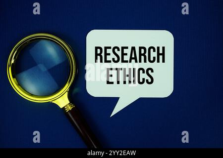 Research Ethics text on speech bubble with magnifying glass top view on blue background Stock Photo