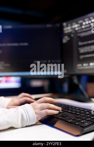 Woman typing on keyboard, implementing security measures to protect company systems and data. Close up shot of IT specialist writing, testing and debugging Java code for software applications, Stock Photo