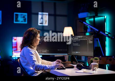 Developer in neon lit apartment implement security measures, protecting company systems and data. System administrator working from home, testing and debugging Javascript code Stock Photo